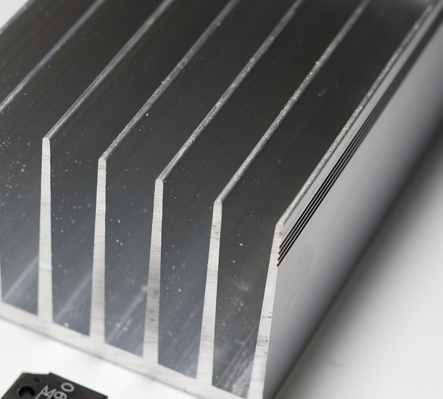 A finned aluminum extrusion photographed on a white surface